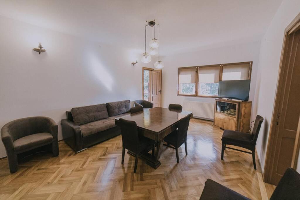 een woonkamer met een bank en een tafel en stoelen bij Predoi's Place in Sinaia