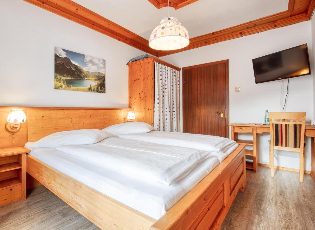 a bedroom with a large bed and a desk at Hotel Kollerhof in Aich