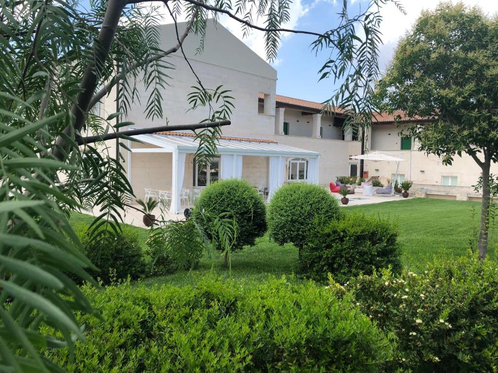 una casa con un patio con arbustos y árboles en Hotel Cave Del Sole, en Matera