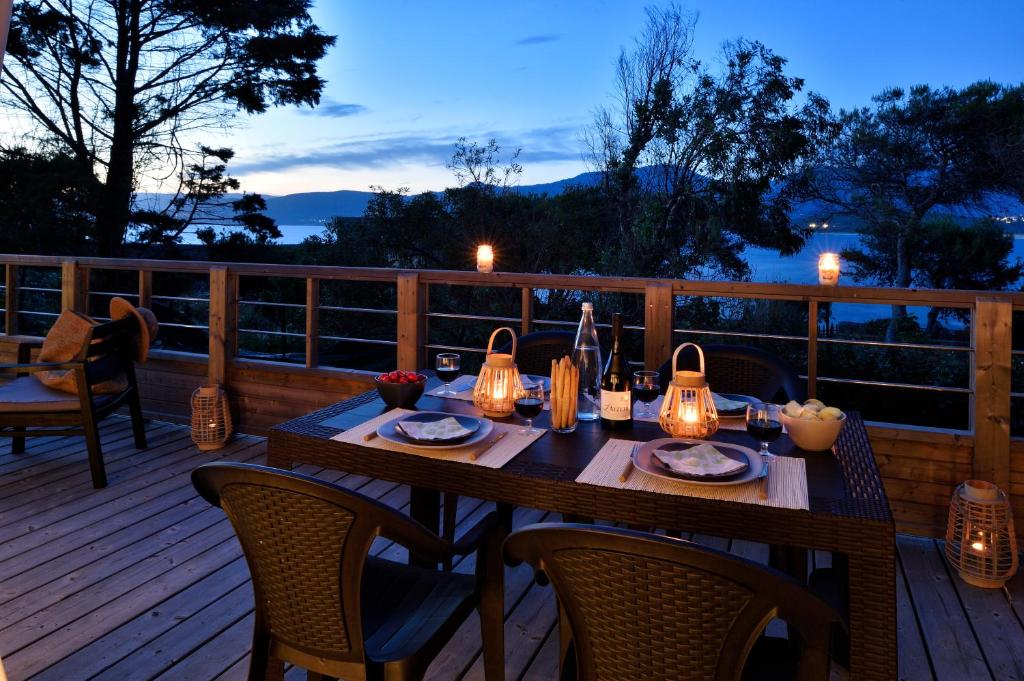 a wooden deck with a table with lights on it at Résidence & Hotel U Livanti ECOLABEL in Propriano
