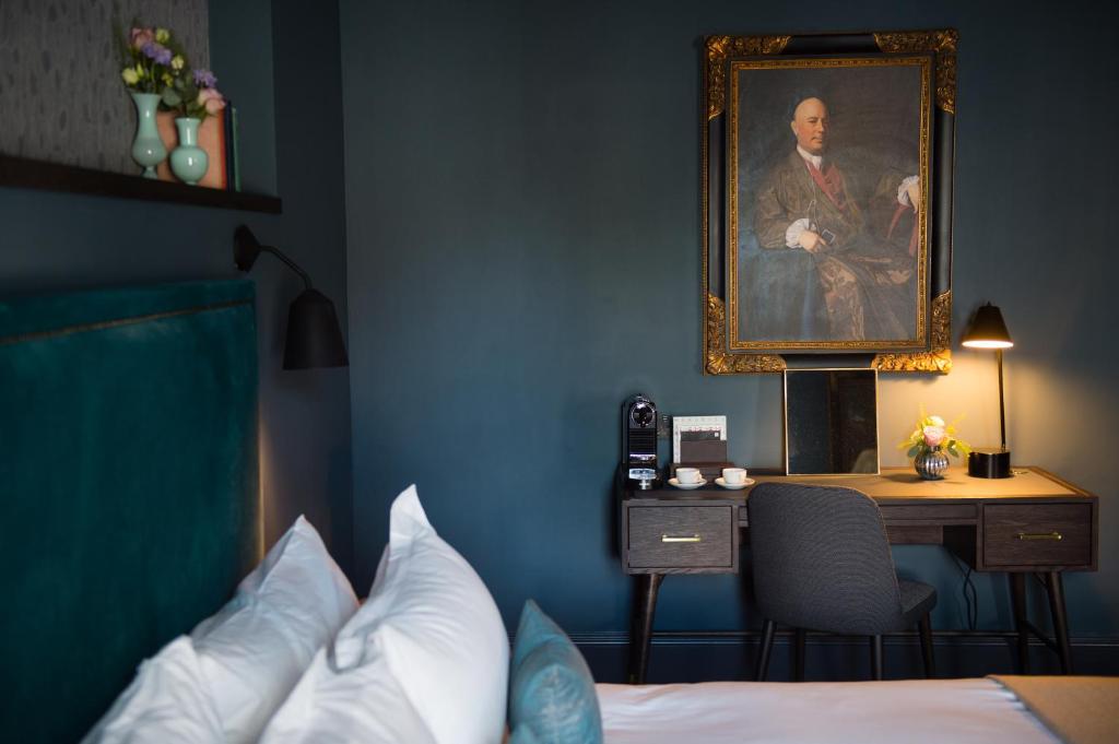 a bedroom with a portrait of a man and a desk at Avon Gorge by Hotel du Vin in Bristol