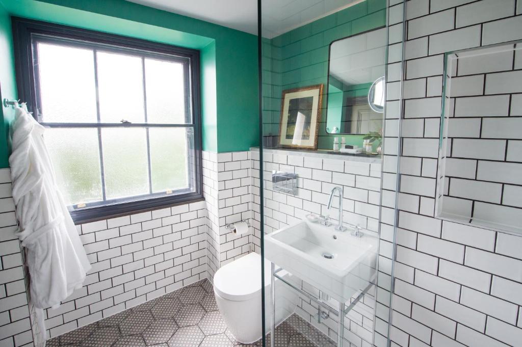 a green and white bathroom with a toilet and a sink at Avon Gorge by Hotel du Vin in Bristol
