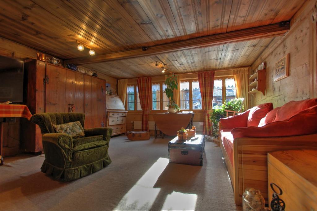 a living room with a couch and a chair at B&amp;B La Pivoine in Rossinière