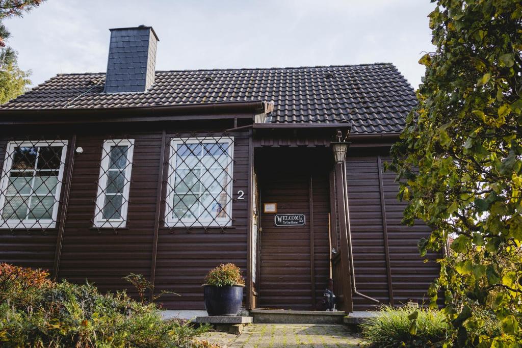 ein Holzhaus mit einer Eingangstür und Fenstern in der Unterkunft Hexenhaus in Neheim-Hüsten