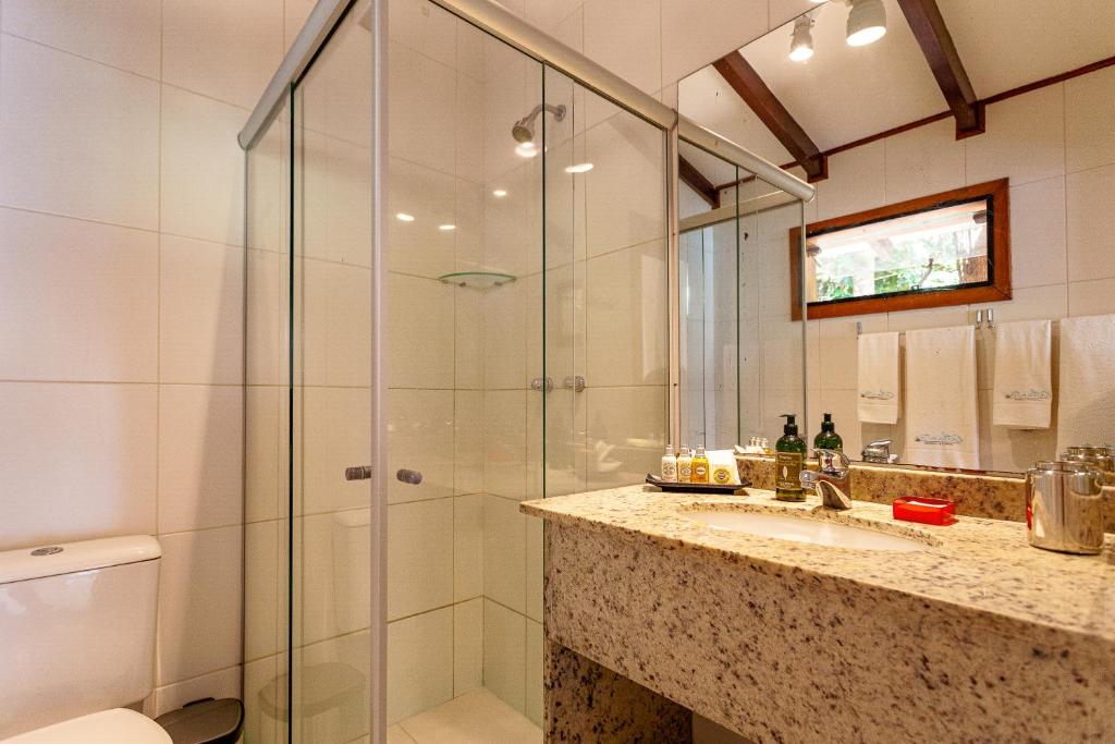 a bathroom with a glass shower and a sink at Atlantica Jungle Lodge in Abraão