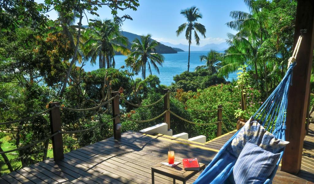 a hammock on a deck with a view of the ocean at Atlantica Jungle Lodge in Abraão
