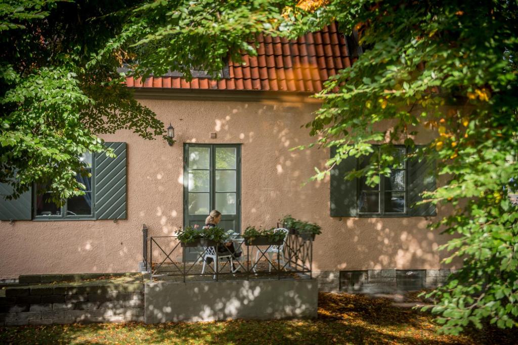 a person sitting on a bench in front of a house at Slottshotellet in Kalmar