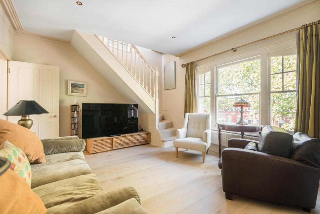 a living room with a couch and a tv at Picturesque Parsons Green by UndertheDoormat in London