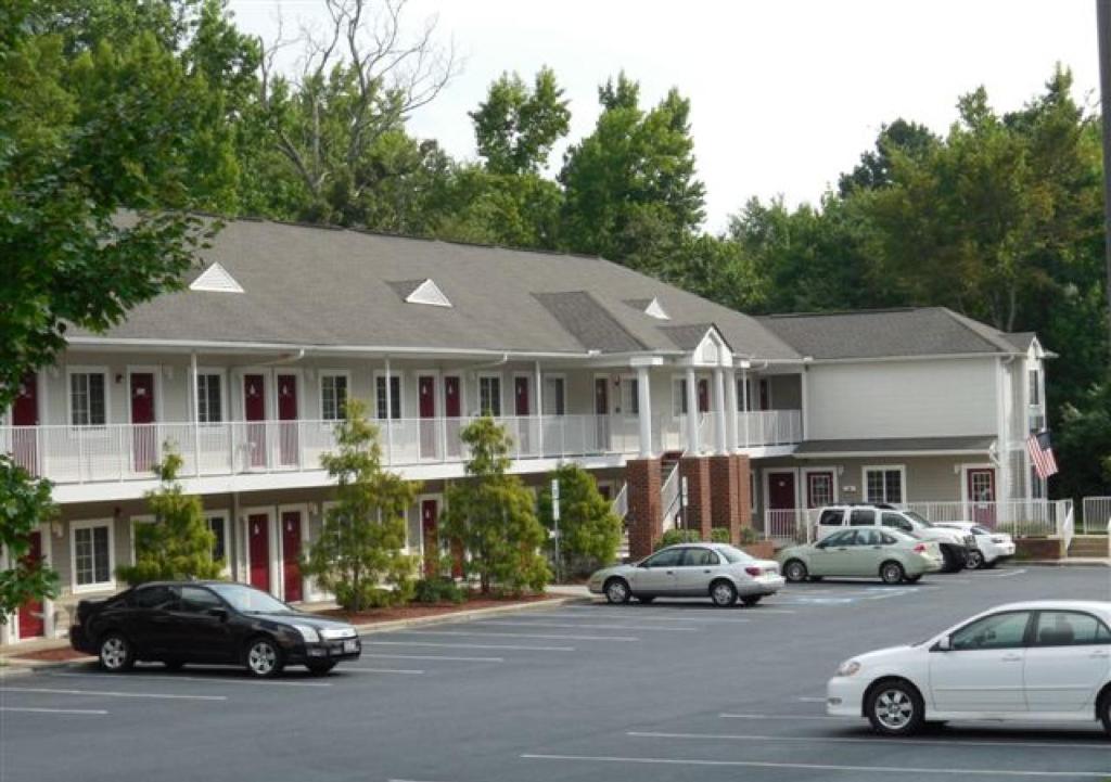 un gran edificio con coches estacionados en un estacionamiento en Affordable Suites Shelby en Shelby