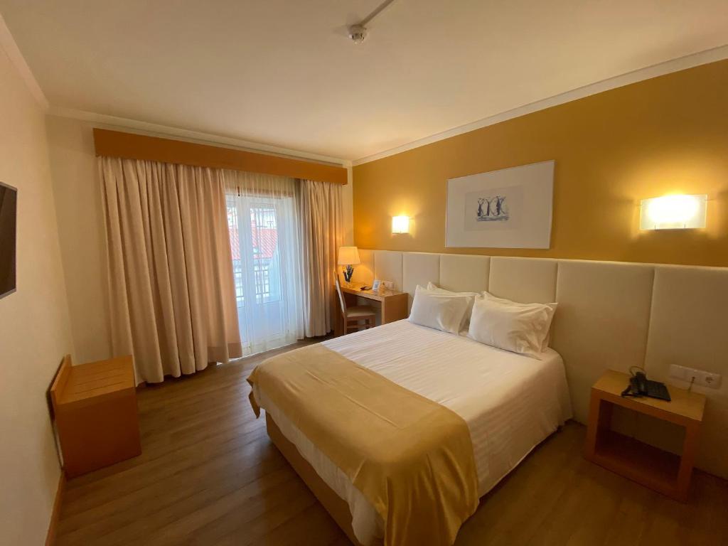 a hotel room with a bed and a window at Hotel Mare in Nazaré