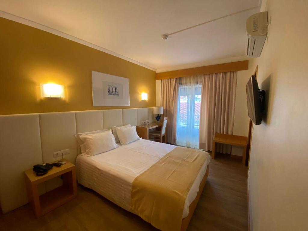 a hotel room with a bed and a television at Hotel Mare in Nazaré