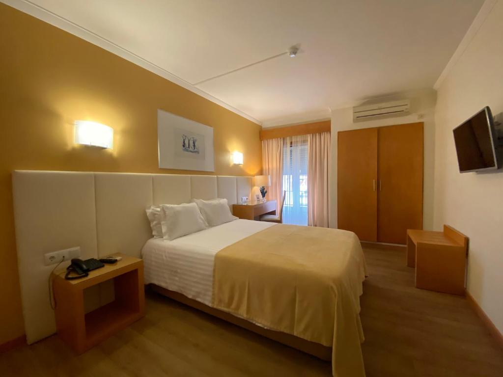 a hotel room with a bed and a television at Hotel Mare in Nazaré