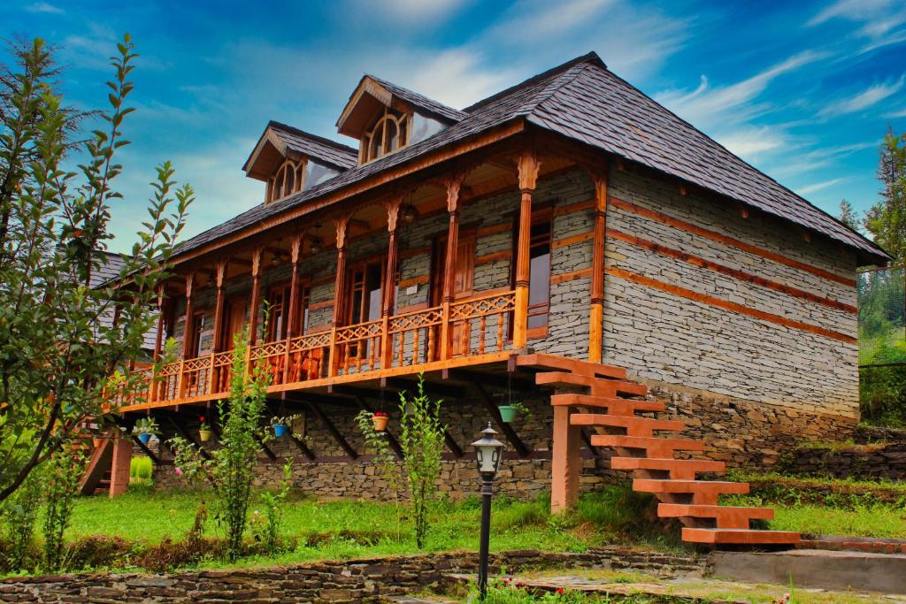 a large wooden house with a wrap around deck at WoodVista Cottages in Shimla