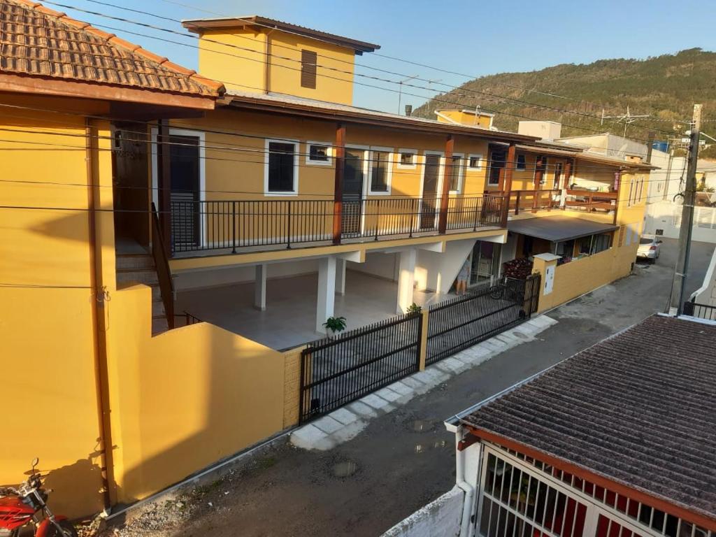 una vista aérea de un edificio amarillo con balcón en Pousada Residencial Caroa en Florianópolis