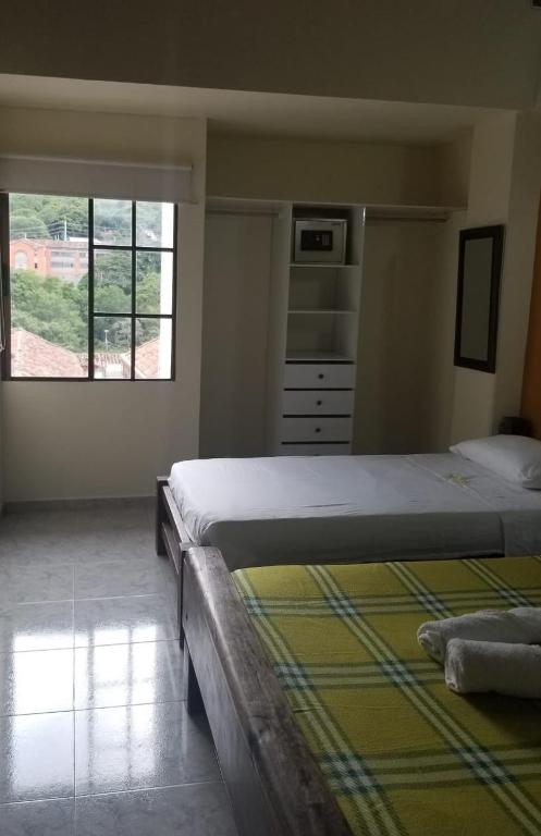 a bedroom with a large bed and a window at Sam'S VIP Hostel San Gil in San Gil