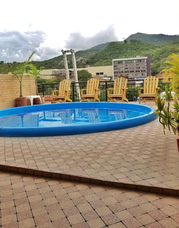 a swimming pool with chairs around it on a patio at Sam'S VIP Hostel San Gil in San Gil