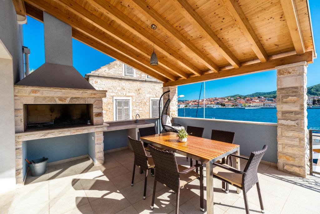 a patio with a wooden table and chairs and a fireplace at Luxury Apartment Marina View No 2 in Vela Luka