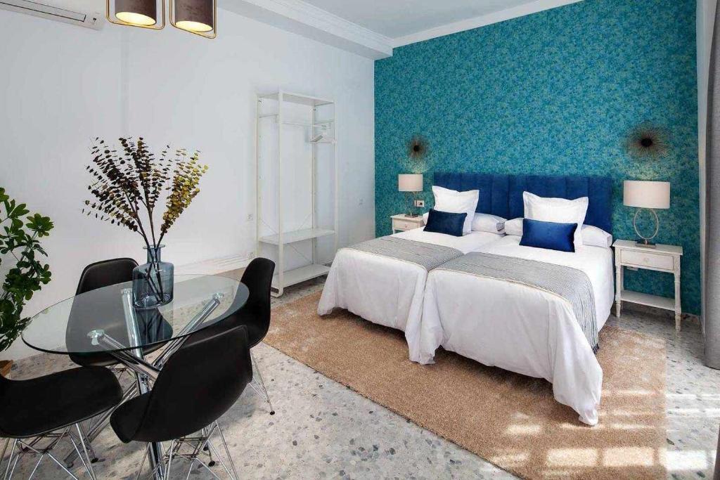 sypialnia z dużym łóżkiem i szklanym stołem w obiekcie Wanderlust Malaga Apartamentos 3 w Maladze
