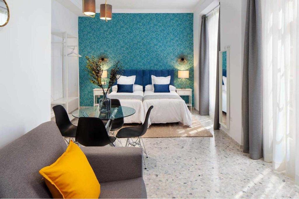 salon z łóżkiem i szklanym stołem w obiekcie Wanderlust Malaga Apartamentos 3 w Maladze
