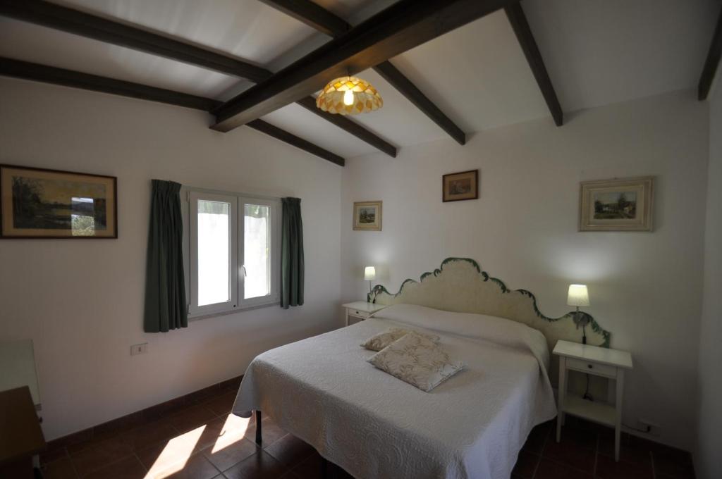 a bedroom with a white bed and a window at Villa Eva in Anacapri
