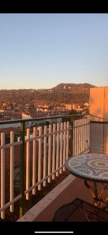 a table on a balcony with a view of a city at Friuli Appartamenti in Cormòns
