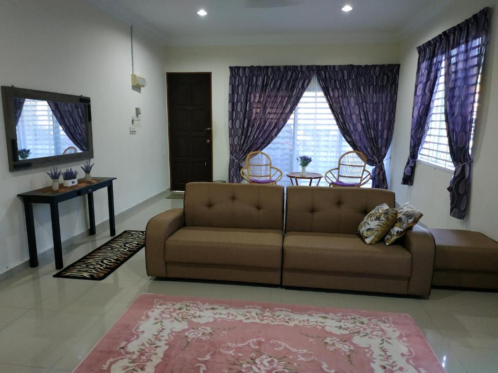 淡馬魯的住宿－Villa Pulai Indah Temerloh，客厅配有棕色沙发和紫色窗帘