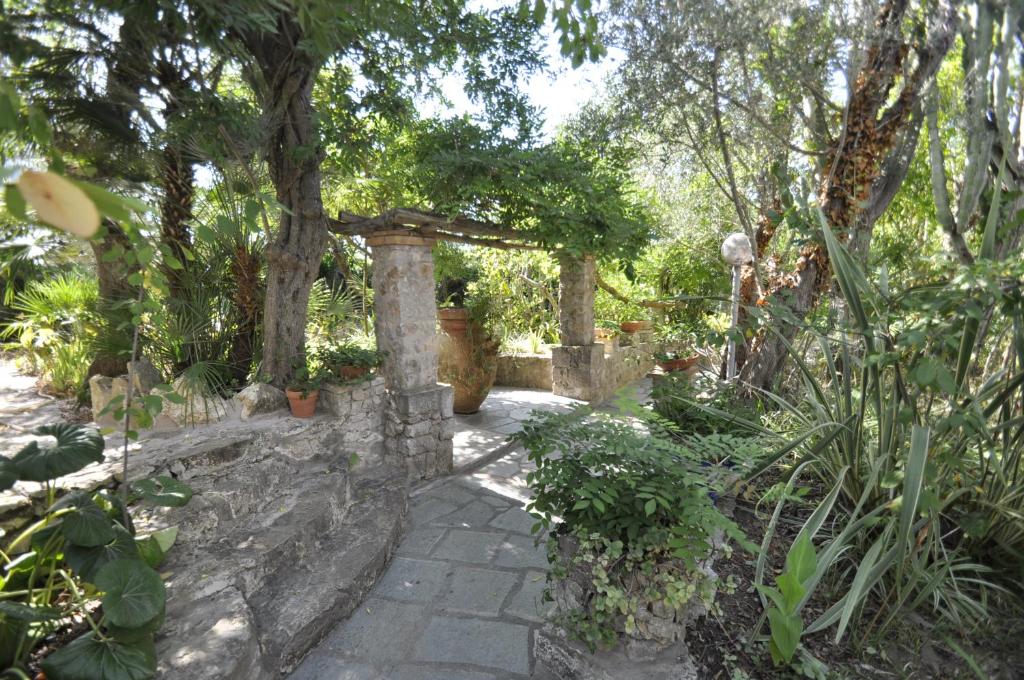 a garden with a stone pathway with trees and plants at Villa Eva in Anacapri