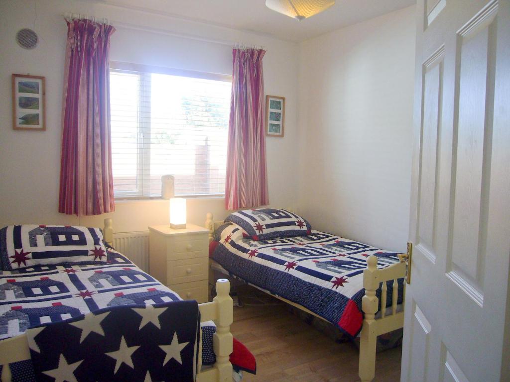 1 dormitorio con 2 camas y ventana en Dacha Holiday Home by Trident Holiday Homes, en Ardmore