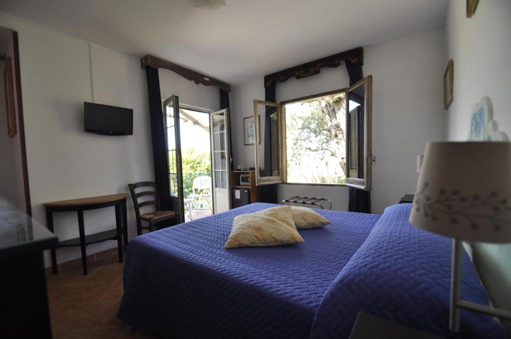 a bedroom with a blue bed with two pillows on it at Villa Eva in Anacapri