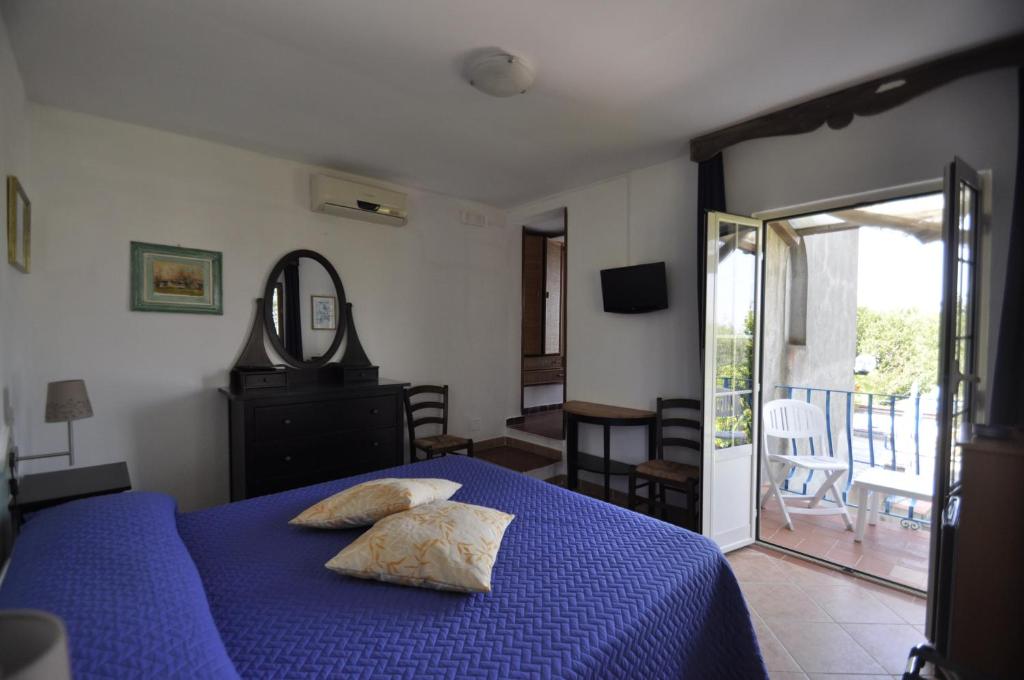 a bedroom with a blue bed with pillows on it at Villa Eva in Anacapri