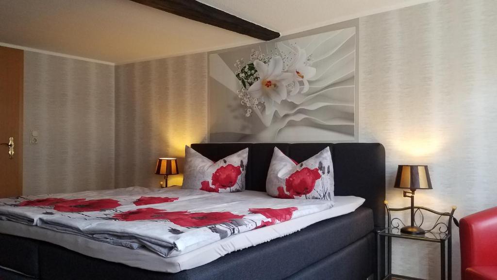ein Schlafzimmer mit einem Bett mit roten Blumen darauf in der Unterkunft Ratsstübchen in Wernigerode