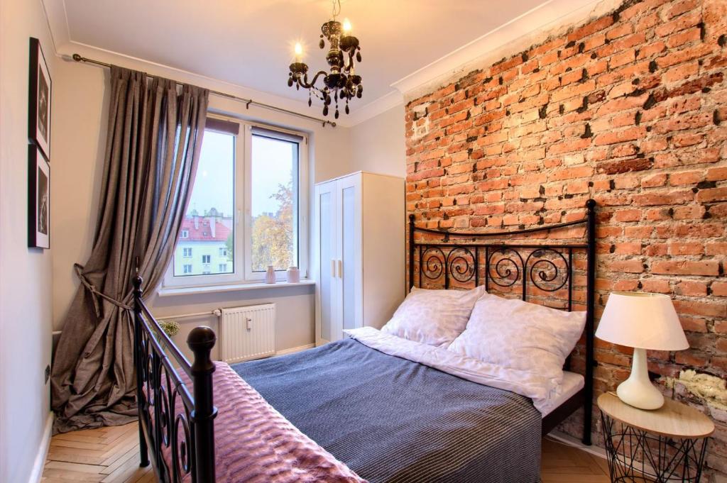 托倫的住宿－Katarzyny11，一间卧室设有砖墙和一张床