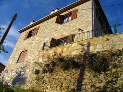 a stone building with windows on top of it at Kirmilis Mansion in Makrinítsa