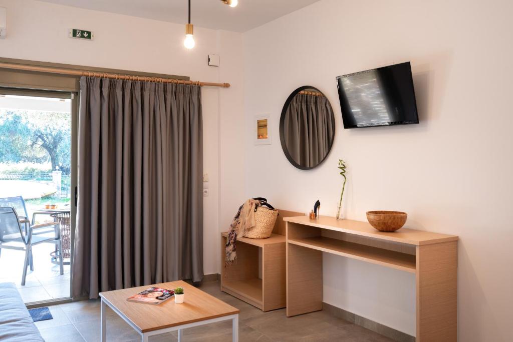 a living room with a table and a tv on the wall at Eutopia Olive Garden in Syvota