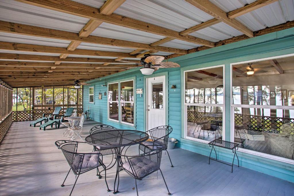 a covered porch with a table and chairs at Cozy Cottage on Lake O The Pines with Lake Views! in Avinger