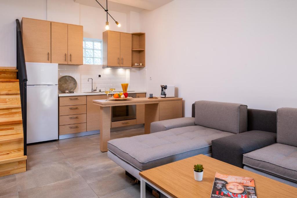 a living room with two couches and a kitchen at Eutopia Olive Garden in Syvota