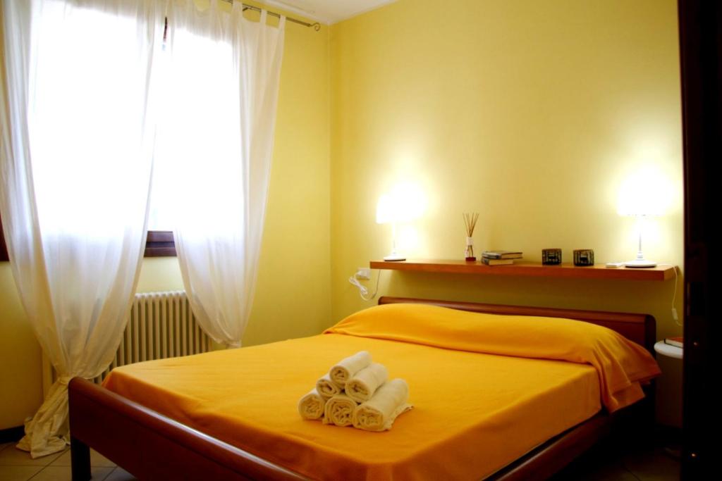 Un dormitorio con una cama amarilla con toallas. en Villa Sole, en Lido di Scacchi