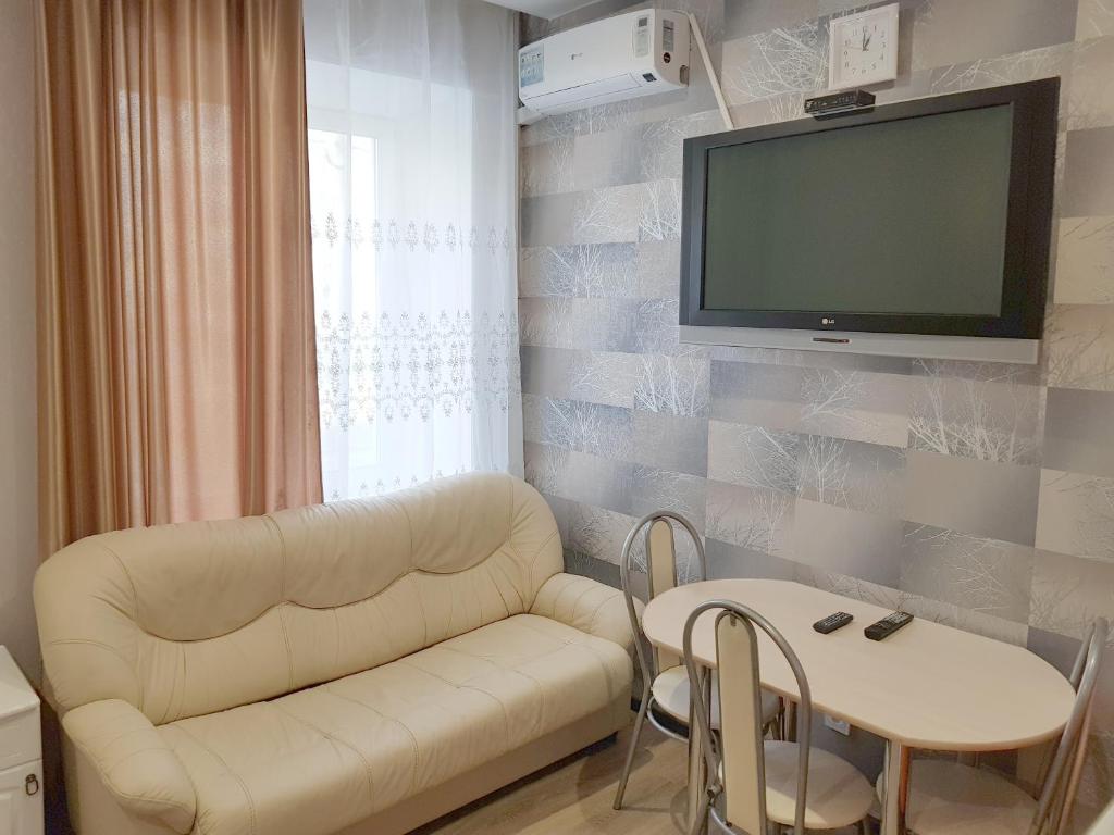 モスクワにあるNa Avtozavodskoy 17 корп 1 Apartmentのリビングルーム(ソファ、壁掛けテレビ付)
