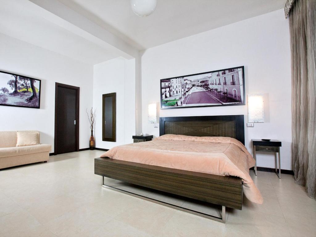 Hotel Grazia Eboli في إبولي: غرفة نوم مع سرير وتلفزيون على الحائط