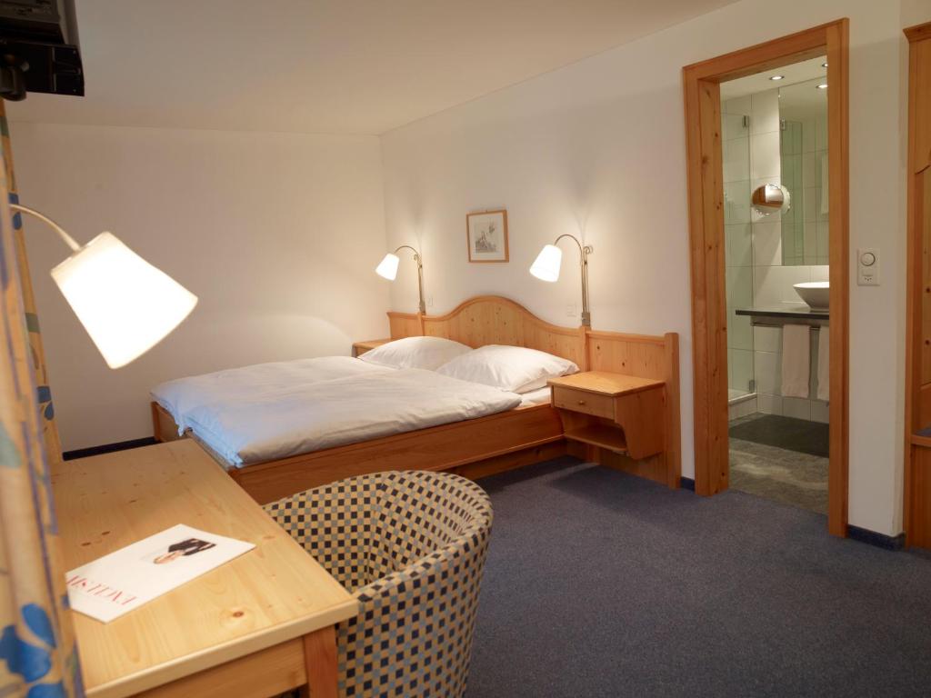 Postel nebo postele na pokoji v ubytování Hotel Alpina Parpan