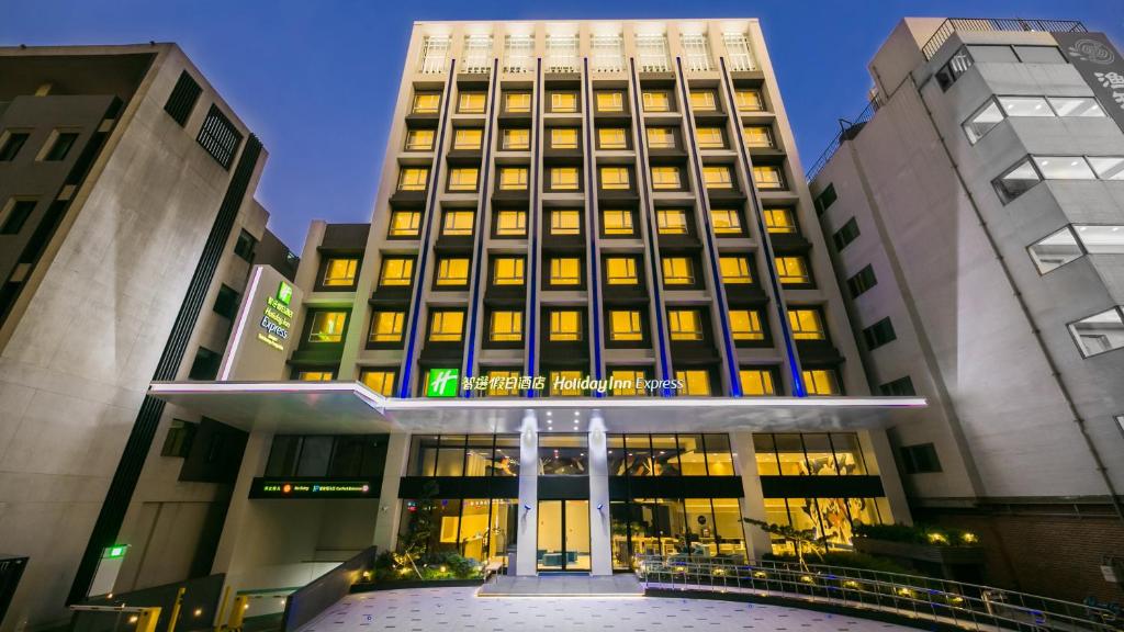 a tall building with lights on in front of it at Holiday Inn Express Taichung Fengchia, an IHG Hotel in Taichung