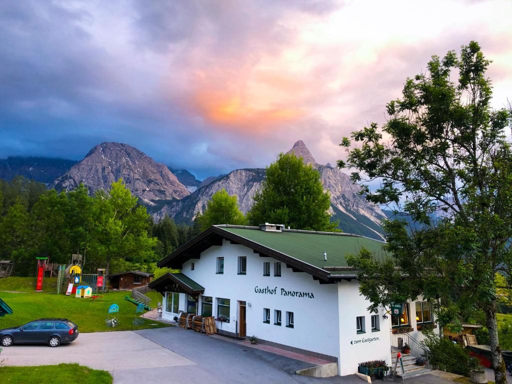 ein Gebäude mit einem Auto auf einem Parkplatz in der Unterkunft Gasthof PANORAMA in Ehrwald