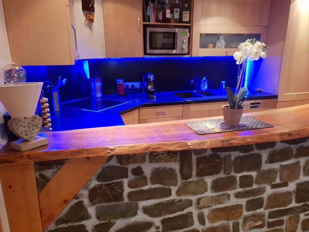 - une cuisine bleue avec un comptoir en bois dans l'établissement Le Havre de paix, à Saint-Dalmas-le-Selvage