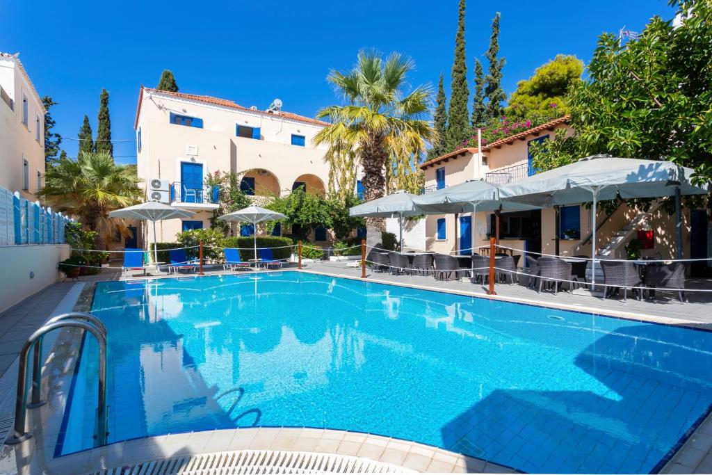 a swimming pool in front of a building at Vanas Apartments in Spetses