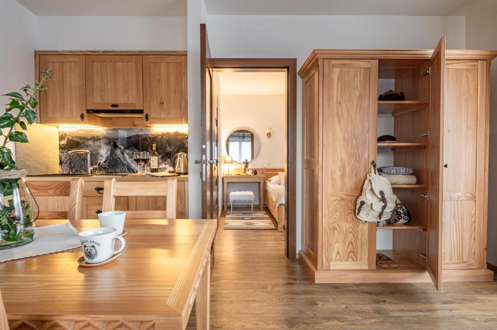 una cocina con armarios de madera y una mesa en una habitación en Willa Kasztan, en Zakopane