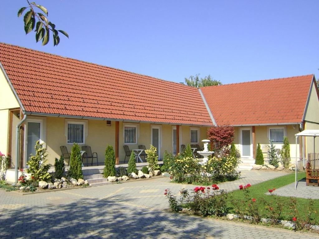 een huis met een oranje dak en een tuin bij Tünde Apartman in Bük