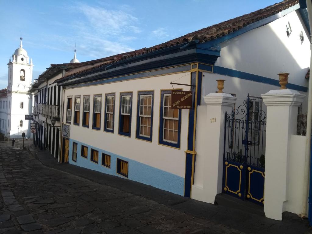 迪亞曼蒂納的住宿－Pousada Dona Dazinha，白色和蓝色的建筑,有钟楼