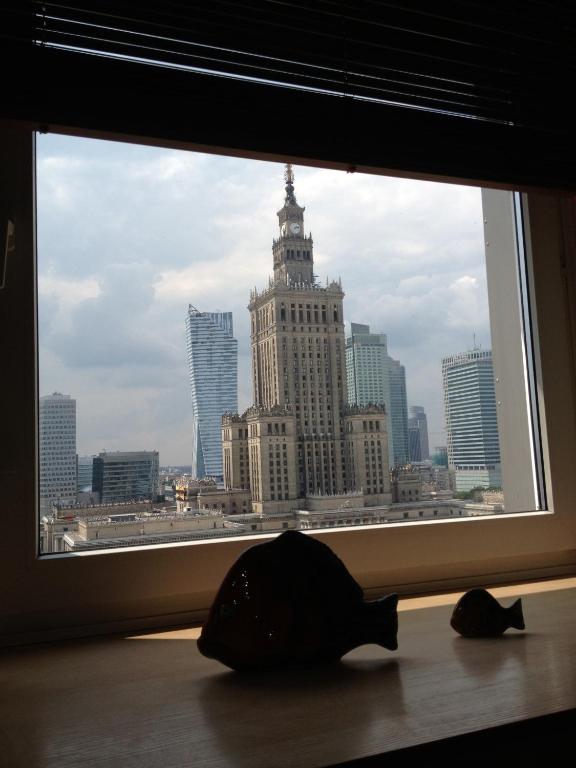a window with a view of a large building at Amica Apartment by WarsawResidence Group in Warsaw
