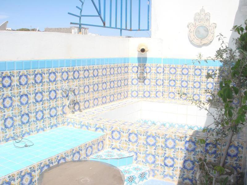 a swimming pool with a blue and white tile wall at Dar Warda in Bizerte