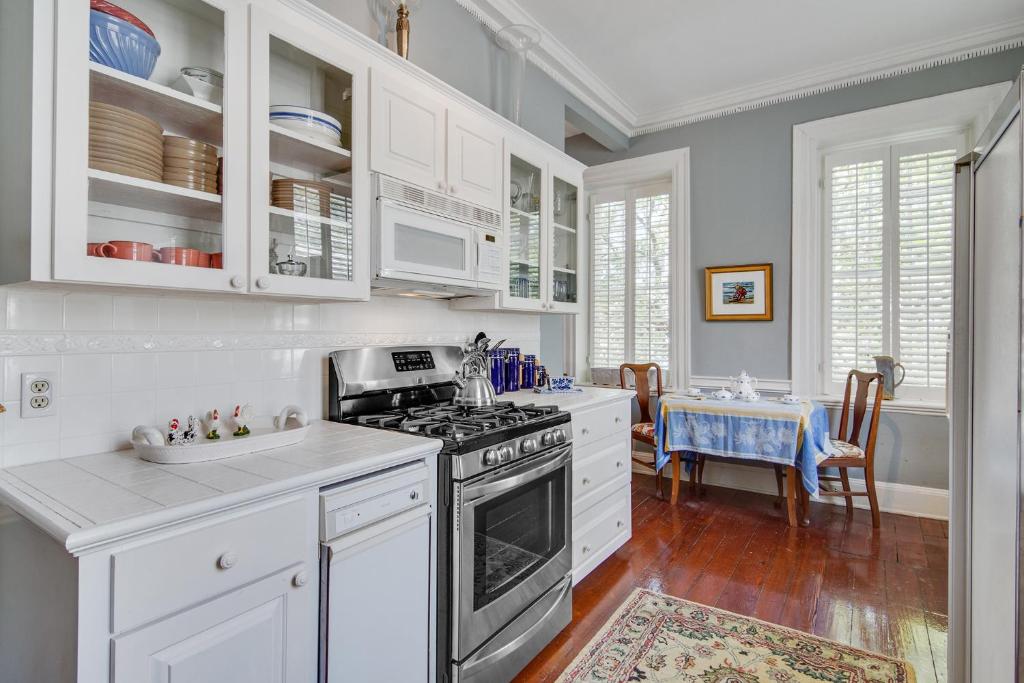 uma cozinha com armários brancos e um forno com placa de fogão em 125 Church em Charleston